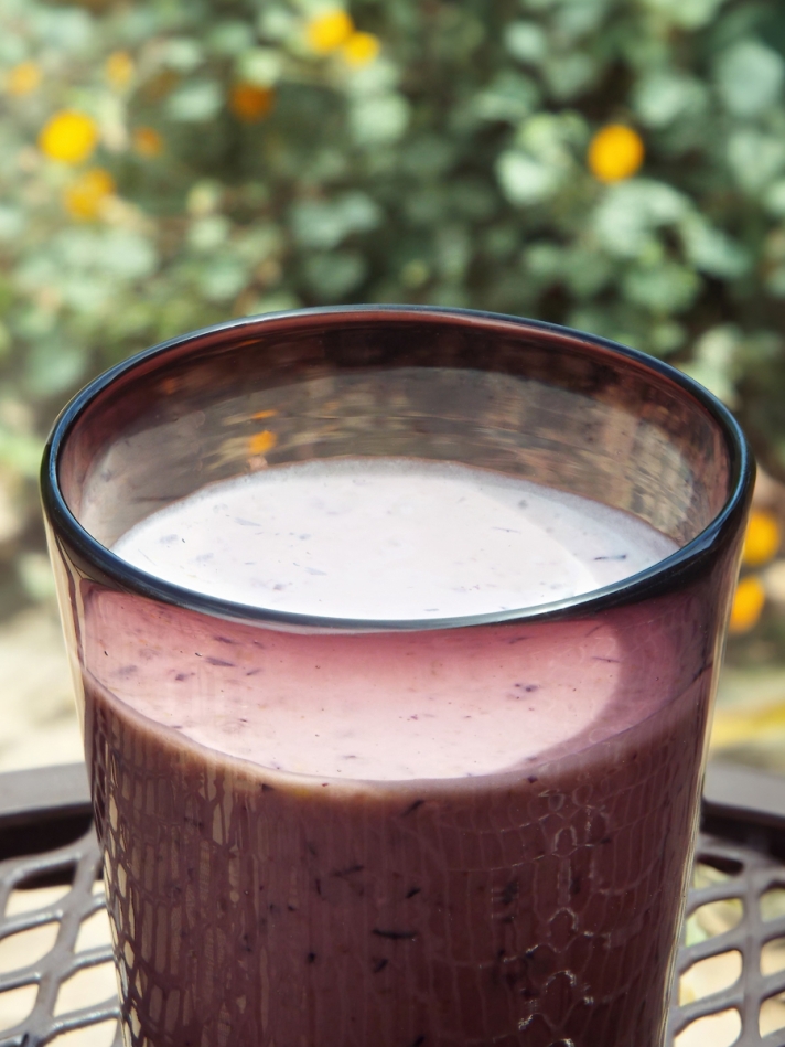 Blueberry breakfast smoothie in an amethyst-colored glass.