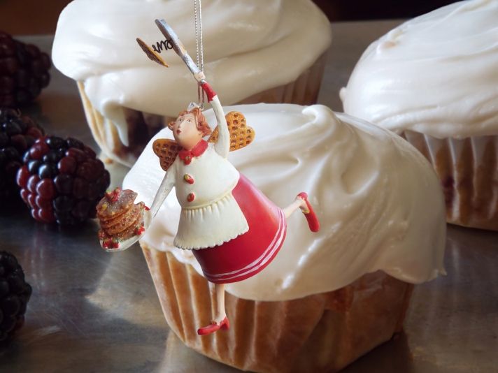 Holiday baker ornament over blackberry cupcakes