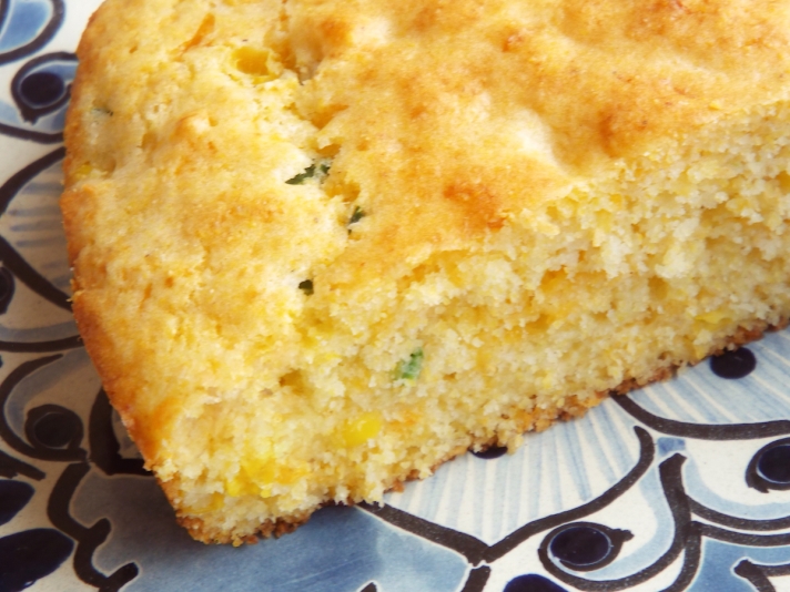 Jalapeño cheddar cornbread slice, served on a blue Talavera plate.