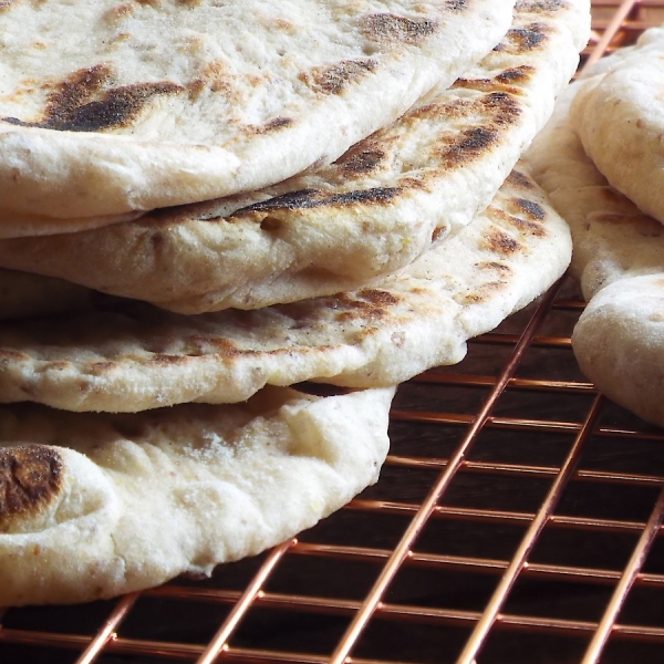 Whole-grain flatbreads stacked on a cooling rack.